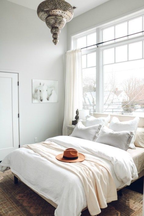 White Boho Bedroom Refresh | Nesting with Grace | Complete with soft layered bedding and neutral colors, this master bedroom makeover has soft linen bedding, a natural vintage rug, and a boho chic lighting for the perfect bedroom retreat.