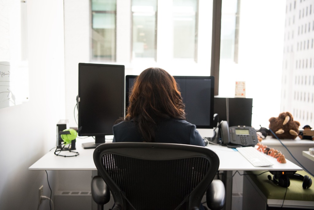 Woman sat in office chair at her desk